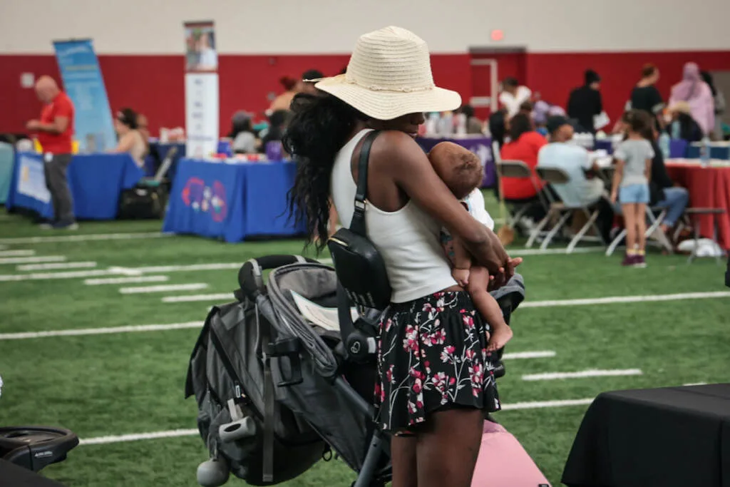 A mother holds her child in the middle of the event room.