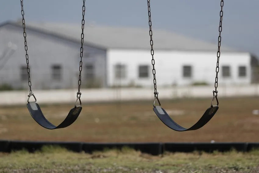 Swings hang in front of the AEG Petroleum, LLC, business, at Guadalupe Elementary School in Lubbock. The North and East Lubbock Coalition has filed a Title VI Civil Rights Complaint against the city, citing discriminatory zoning practices.