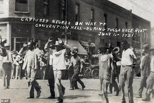 A group of black men are marched past the corner of 2nd and Main Streets in Tulsa, Oklahoma