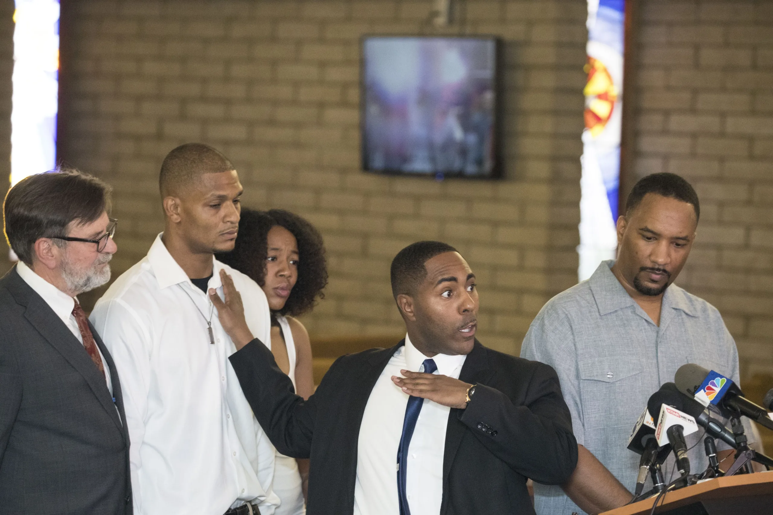 Robert Johnson, a 33-year-old man who was beaten by Mesa police officers in May, lawyer Joel Robbins (left), attorney Benjamin Taylor (center) and Pastor Andre Miller (far right) speak at New Beginnings Christian Church in Mesa on June 7, 2018.