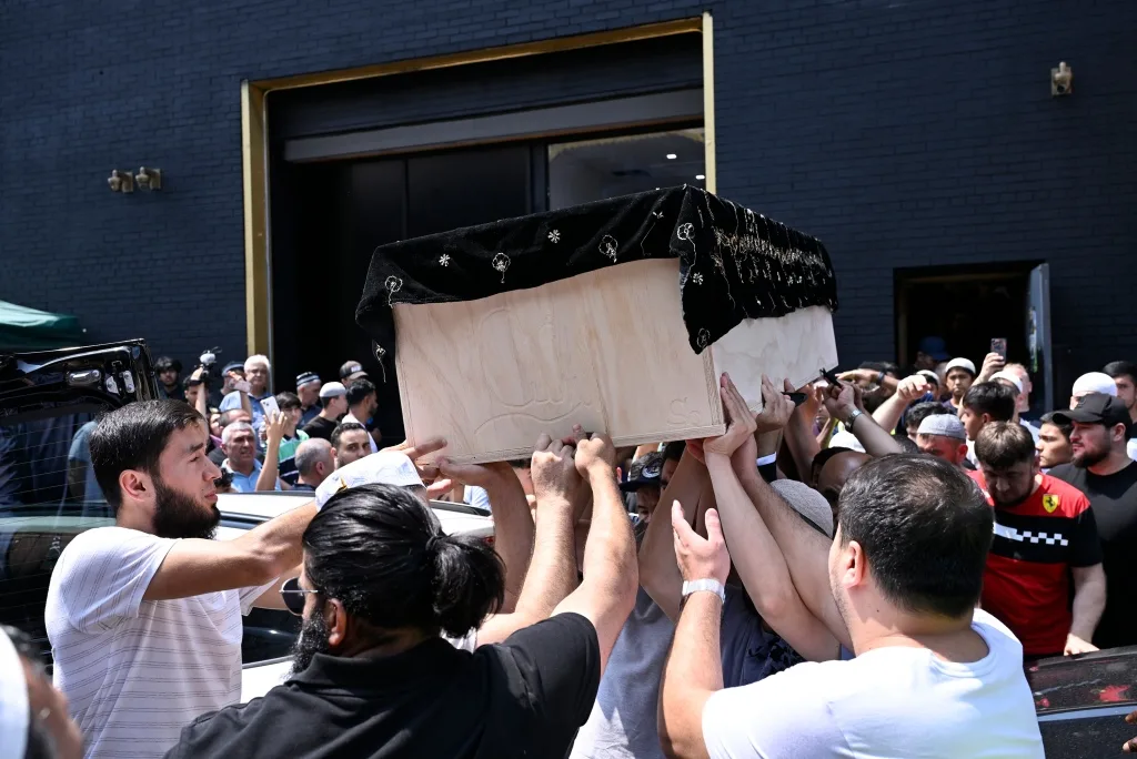 Mavlonov's coffin getting carried into a Muslim center in Brooklyn for his funeral service on June 20, 2023.