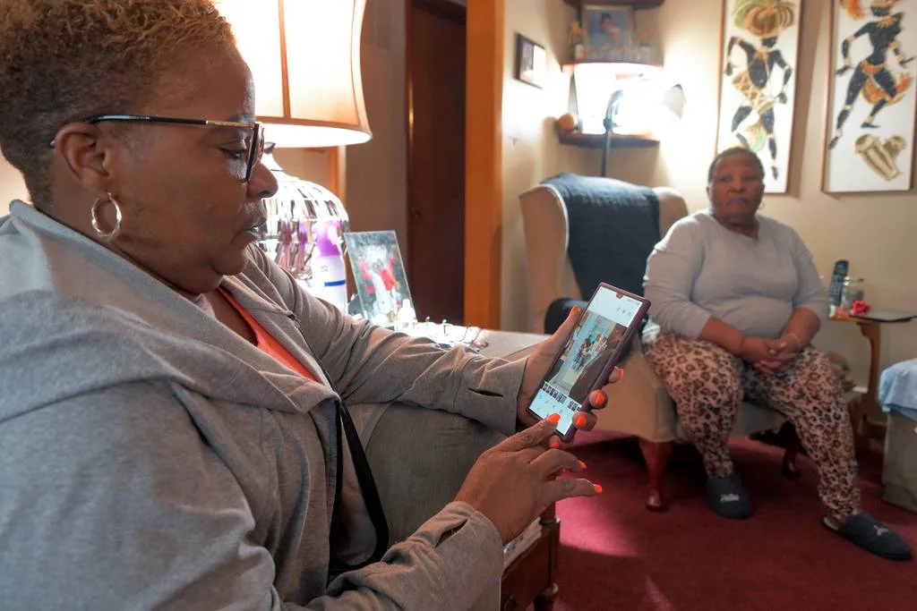 Samantha Hart – daughter of Henry Hart, who has dementia – looks at a photo of the release of her father from police custody while her mother, Rosalind Hart, looks on at the Hart home. The family filed a complaint with Baltimore County after his health declined when he was taken to jail.