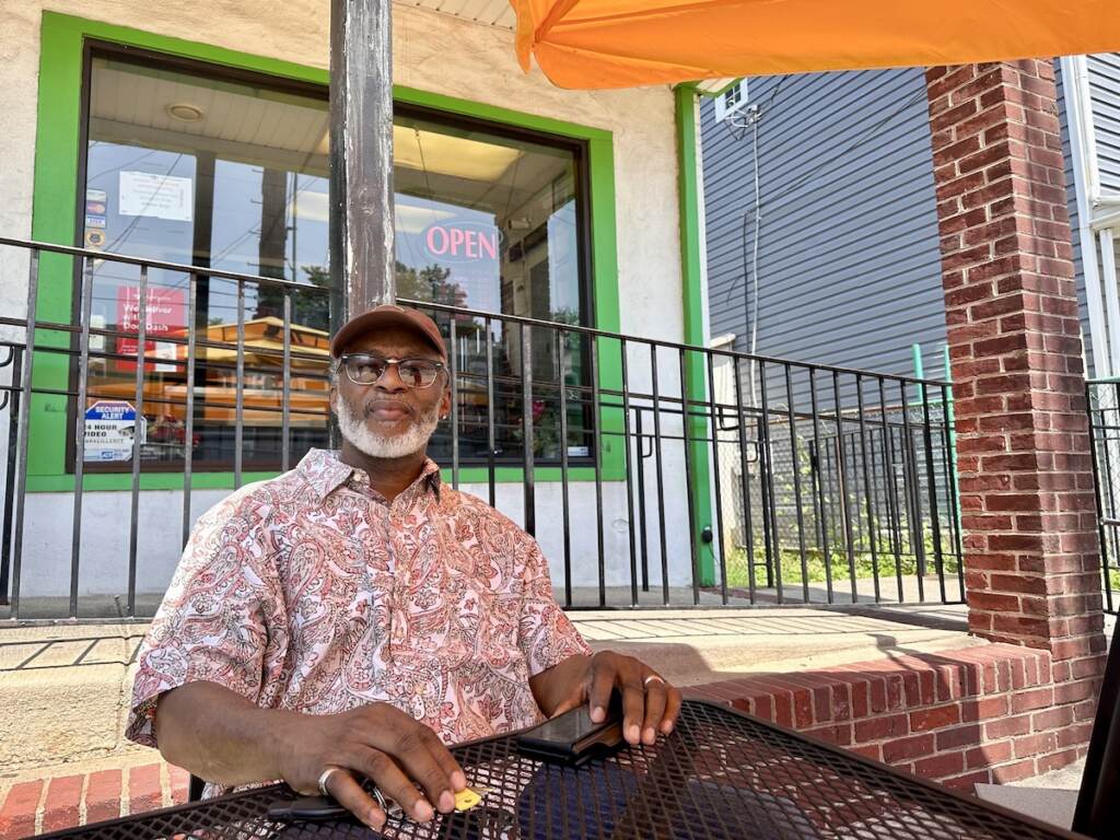 Larry Fletcher sits at a table outside of his restaurant.