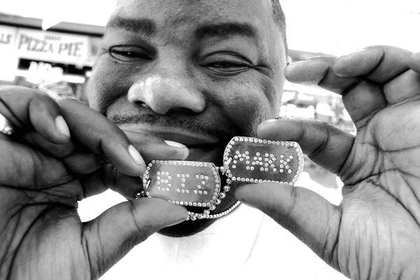 Biz Markie holding up his chain.