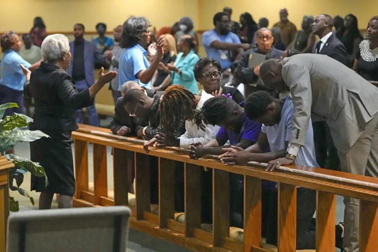 Church members at the St. Paul A.M.E. Church pray with four Edward Waters University students at a prayer service on Aug. 27, 2023, for the victims of a mass shooting in Jacksonville, Fla.