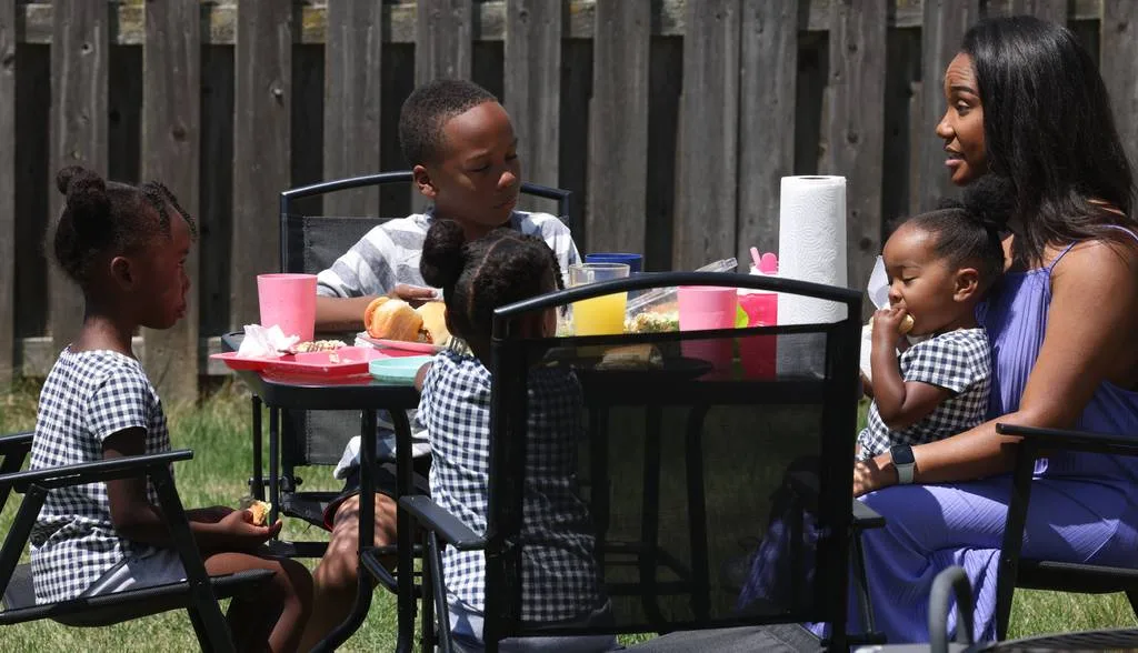 Shay Dunn, right, eats lunch outdoors in the backyard of her home with her children Nova, 6, from left, Khai, 9, Summer, 4, back to camera, and Phoenix, 1, in Montgomery on July 10, 2023. 