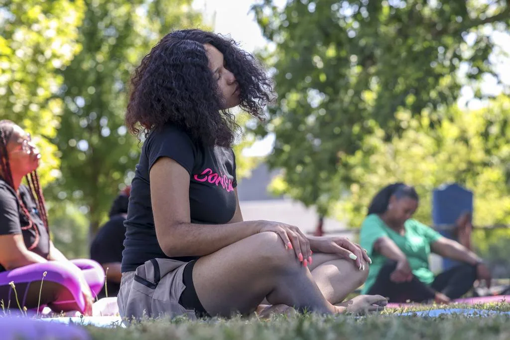 Cori Alexander stretches her neck during a yoga self-care event on June 24, 2023, in South Shore. Hosted by the Free Root Operation, the event is part of a series dedicated to investing in black mothers. 
