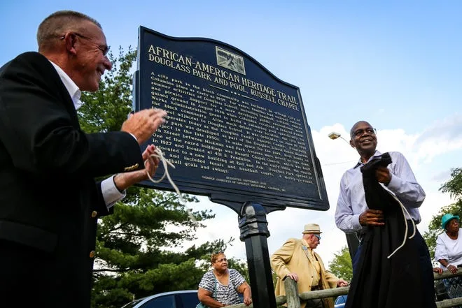 Former Shelter Insurance CEO Matt Moore and Jim Whitt, who was chairman of the Sharp End Heritage Committee, reveal a heritage sign for Douglass Park and Pool and the original Russell Chapel during a Sept. 18, 2018 dedication ceremony. Whitt would establish a foundation to support minority- and women-owned businesses. After adding entrepreneurial workshops this year, the foundation will hold an inaugural golf tournament and dinner fundraiser Aug. 15.