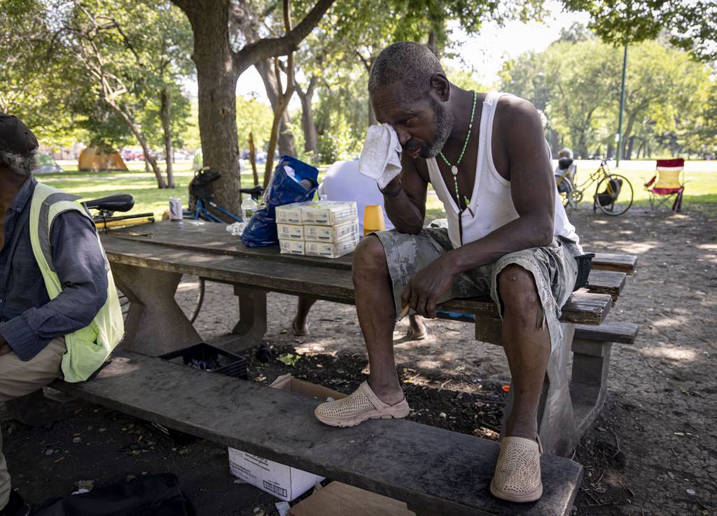 Frank “Mississippi” Smith, 62, wipes sweat as temperatures hit 99 degrees, Aug. 23, 2023, at the Humboldt Park tent encampment where he has been staying with other homeless people for the last two years.