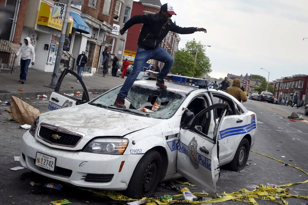 Protester stomps on a police car