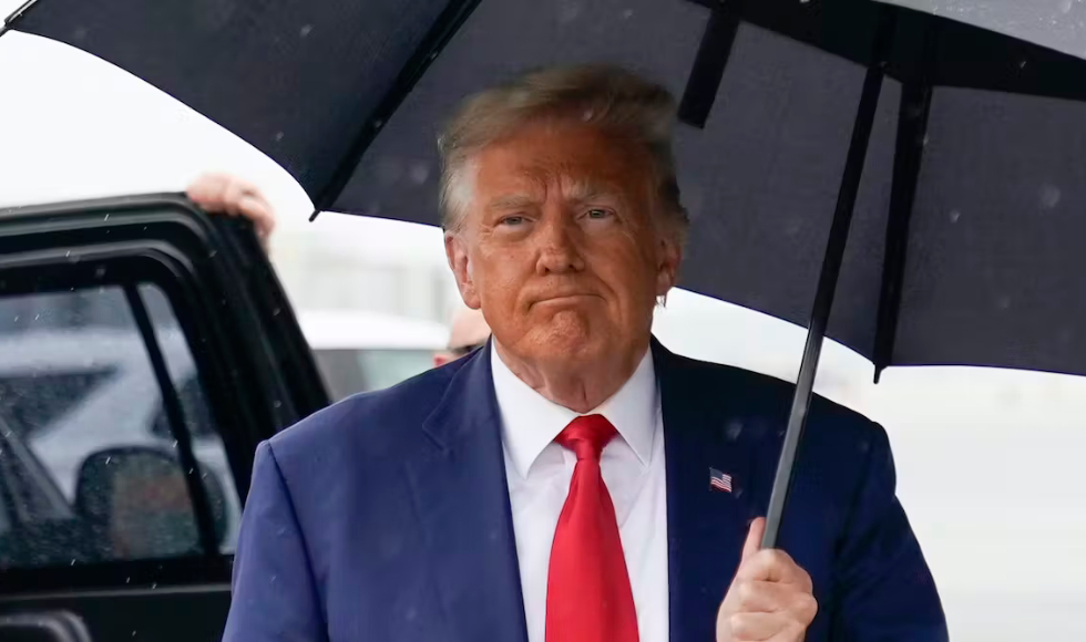 Donald Trump holding up an umbrella