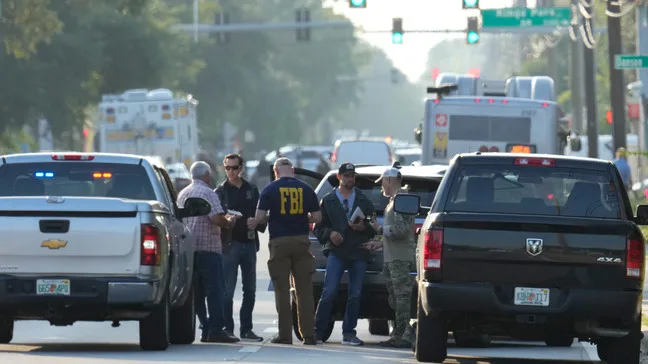 Law enforcement officials investigate the scene of a mass shooting at a Dollar General store, Saturday, Aug. 26, 2023, in Jacksonville, Fla. (AP Photo/John Raoux)