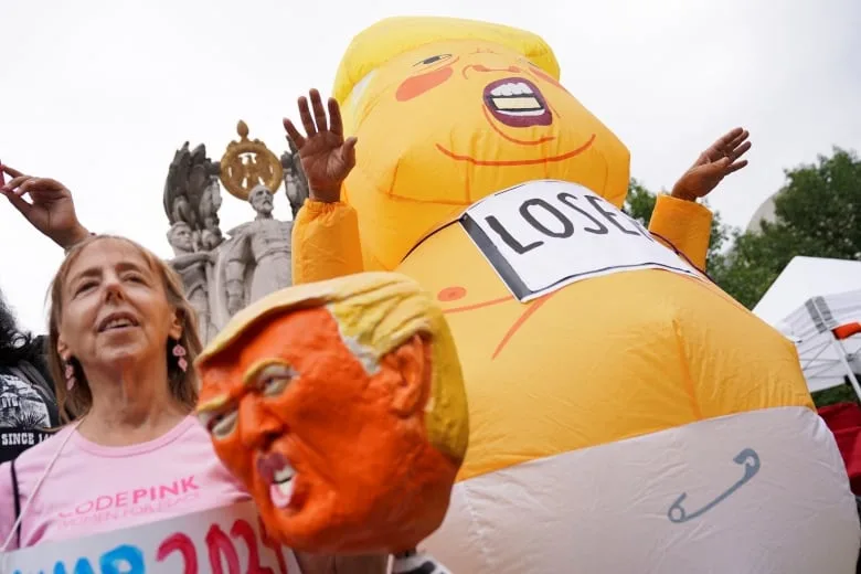 Anti-Trump protest featured giant yellow plastic doll likeness of him dressed as a baby and inscribed with 'Loser'