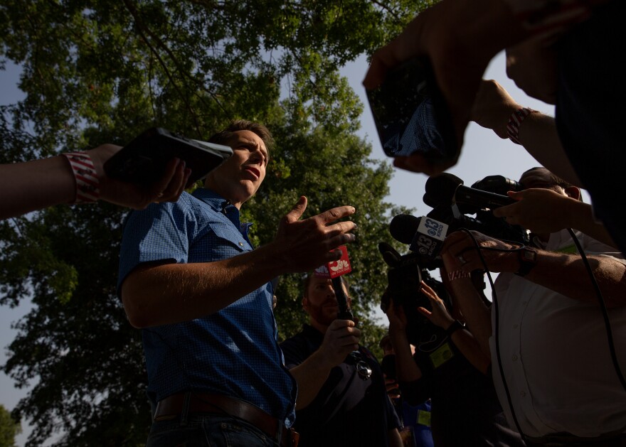 Missouri politician Josh Hawley speaks to reporters. The scene is photographed from a worm's eye view.