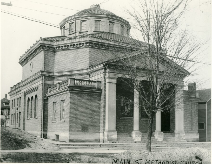 A black-and-white photo of the ornate Main Street Methodist Church, with Classical architecture that includes columns and a dome at the top. 