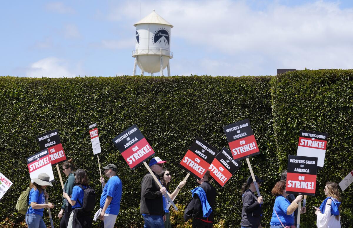 People on strike hold signs.