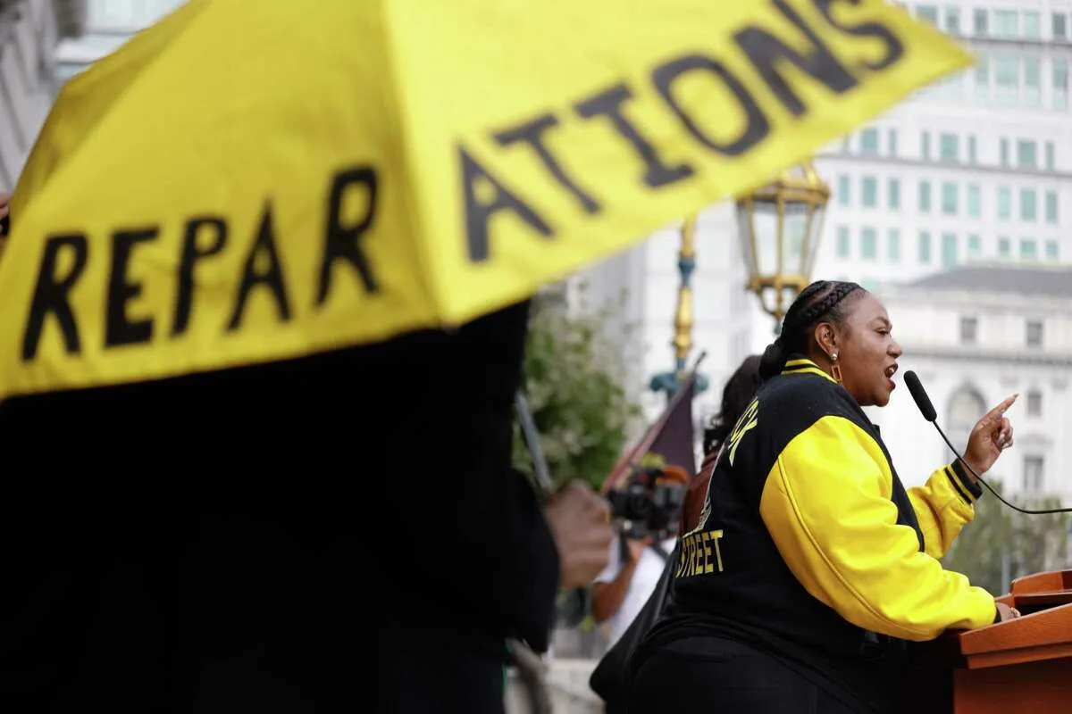 Tinisch Hollins, vice chair of the African American Reparations Advisory Committee, speaks during a rally in support of the recommendations put forward by her committee's recommendations.