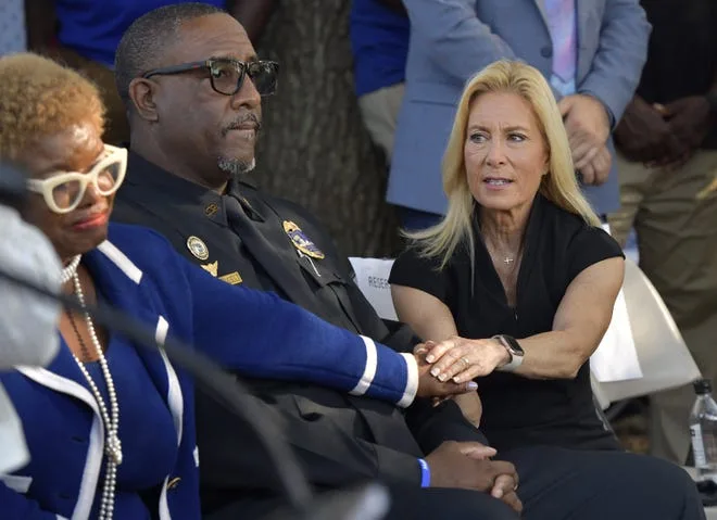 On Aug. 27, 2023, Jacksonville Mayor Donna Deegan reaches across Sheriff T.K. Waters to take council member Ju'Coby Pittman's hand after Pittman's emotional appeal for help for the citizens of her district during Sunday evening's prayer vigil for victims of Aug. 26, 2023 mass shooting at the Dollar General store on Kings Avenue.