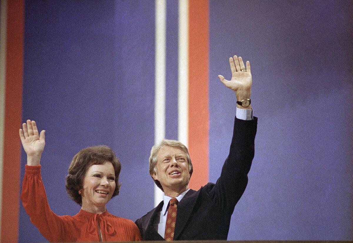 Jimmy Carter and Rosalynn Carter wave.