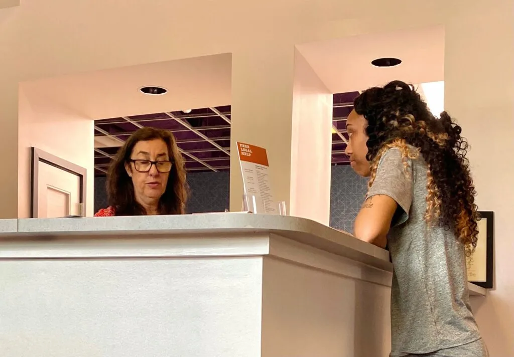 At Cares community office, Baltimore-based energy justice advocate Laurel Peltier, left, talks to Sharde Whelchel, who had her power cut off over nonpayment of utility bills after she switched to a third-party supplier that promised her lower electricity rates. Credit: Aman Azhar/Inside Climate News