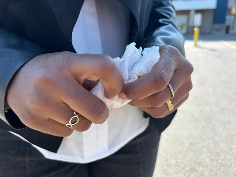 Someone's hands holding a facial tissue.