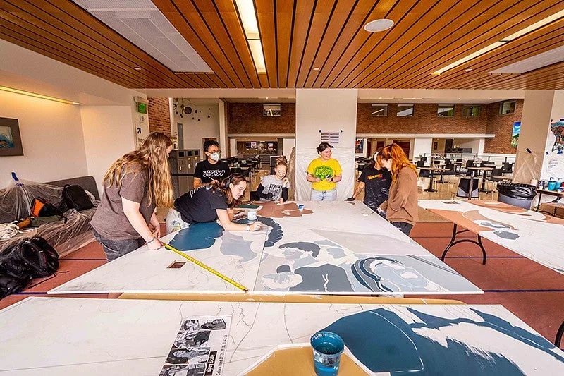 Students painting a mural panel
