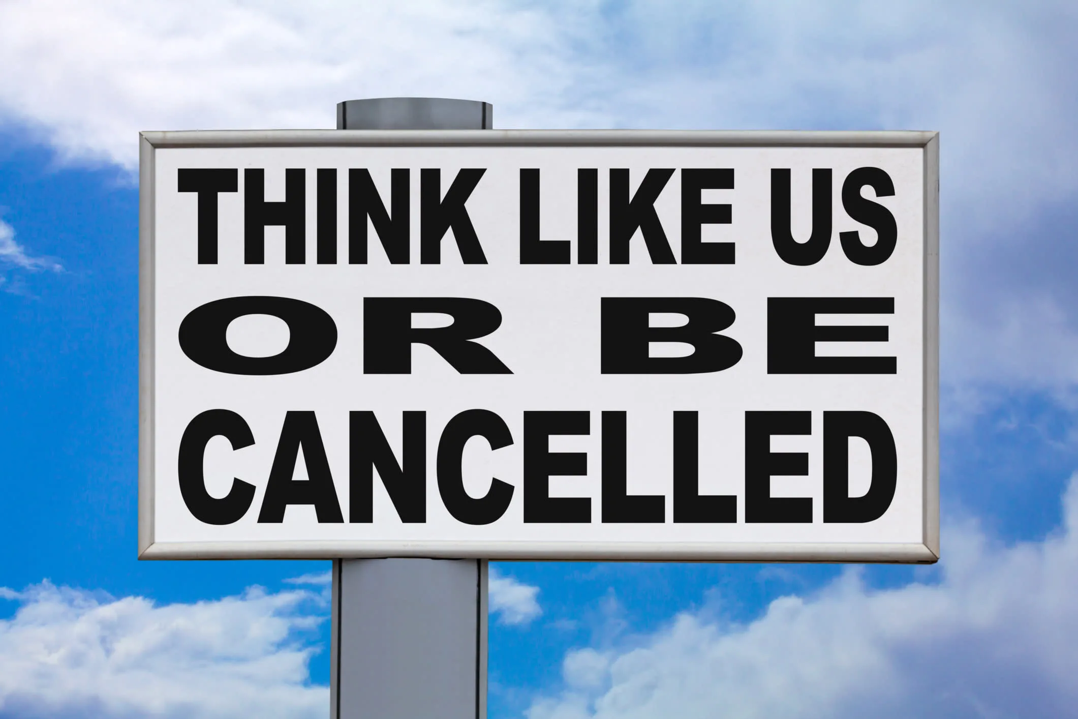 A sign with the words: Think like us or be cancelled written on it against a blue sky with clouds.
