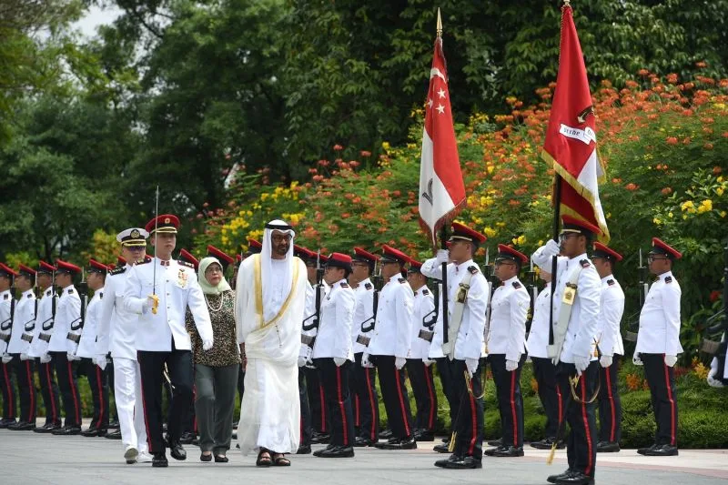 Abu Dhabi Crown Prince Mohamed bin Zayed Al Nahyan, followed by Singaporean President Halimah Yacob, inspects a guard of honor at the Istana presidential palace.