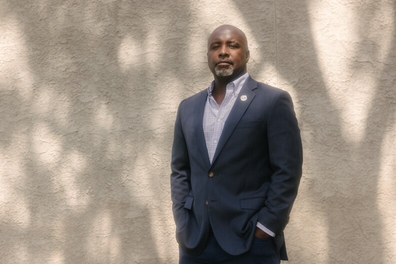 Councilmember Marqueece Harris-Dawson photographed near USC. He has dark skin tone and is wearing a suit, looking at the viewer.