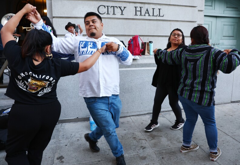 Four protesters dance outside City Hall while calling for the resignations of L.A. City Council members Kevin de Leon and Gil Cedillo in the wake of a leaked audio recording on October 12, 2022 in Los Angeles, California.