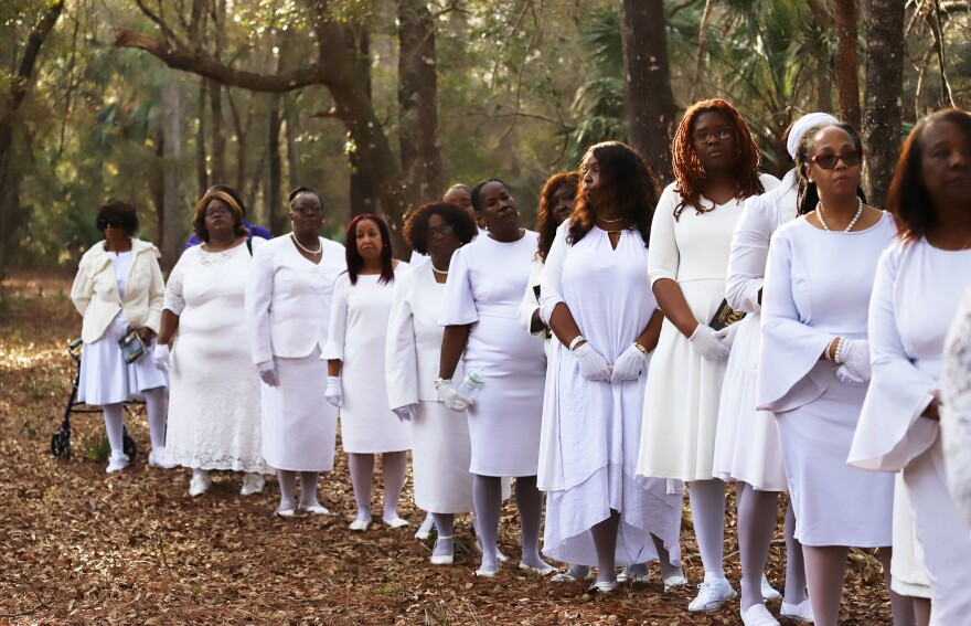 The descendants of the Rosewood massacre stand along the railway during the wreath-laying ceremony at Rosewood, Fla., Sunday, Jan.8, 2023. (Xinyue Li/Fresh Take Florida) 