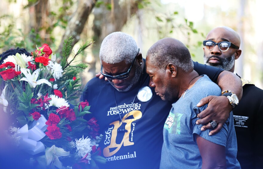 Dr. Kenneth Nunn (Left) and Benjamin L. Crump (Right) mourn for the victims of the Rosewood massacre that occurred a hundred years ago during a wreath-laying ceremony, at Rosewood, Fla., Sunday, Jan. 8, 2023. 