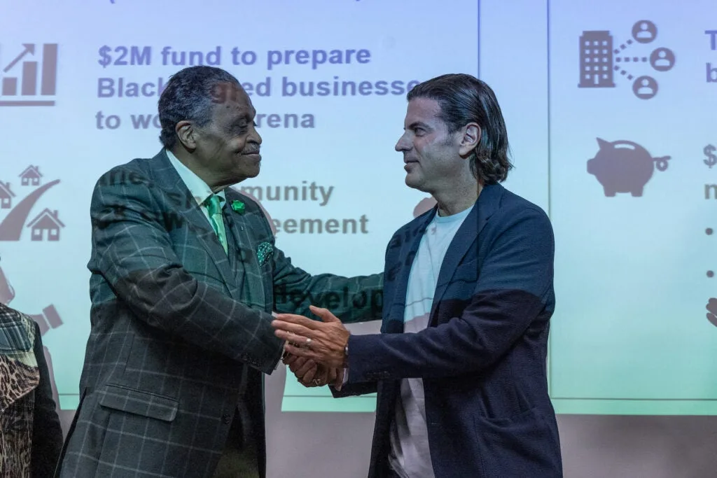 Rev. Robert Collier Sr. shaking hands with David Adelman