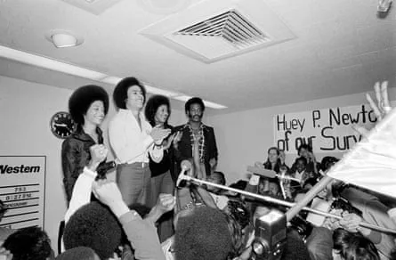 four people smiling in front of crowd