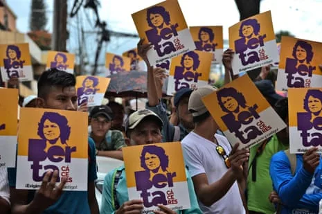 Members of the Council of Popular and Indigenous Organisations of Honduras (COPINH) hold posters with an image of the killed Indigenous leader and environmental activist Berta Caceres.