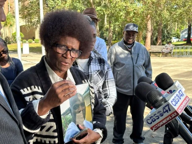 Mary Cure holds a framed photo of her slain son, Leonard Cure, as she speaks to reporters Wednesday, Oct. 18, 2023, in Woodbine, Ga. A Camden County sheriff's deputy fatally shot Leonard Cure after pulling him over for reckless driving on Oct. 16, 2023. Three years earlier, he was freed from a Florida prison after serving 16 years for an armed robbery that officials later concluded he didn't commit. (AP Photo/Russ Bynum)