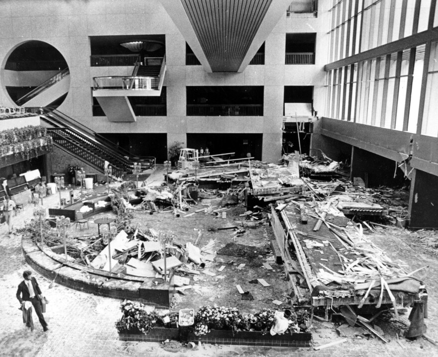 An unidentified man walks through the scattered wreckage in the lobby of Kansas City's Hyatt Regency Hotel on Sunday, July 19, 1981.  Two catwalks spanning the lobby crashed onto a crowded dance floor on Friday night, killing 111 people and injuring 188 others