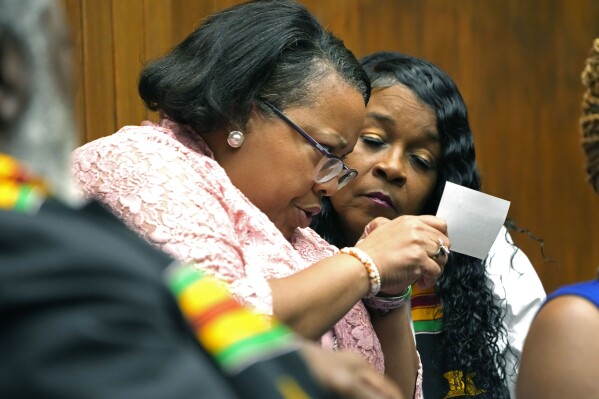 Monitors review a card with a submitted question from an attendee during a candidates forum, Oct. 26, 2023, in Vicksburg, Miss. (AP Photo/Rogelio V. Solis)