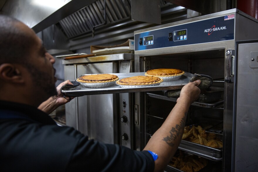 Food truck chef Emanuel Garrett places a tray of sweet potato pies into a warming rack on Wednesday, Nov. 15, 2023, at Ol’ Henry’s Restaurant in Berkeley, Mo. Sweet potato pie is a significant touchstone of African American culture, especially around Thanksgiving.