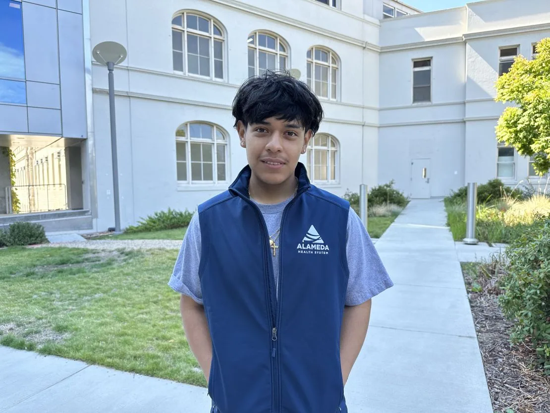 Javier Velasquez Lopez interned at Wilma Chan Highland Hospital Campus after gunmen stormed his East Oakland High School last year. Velasquez Lopez says many people he knows own guns because Oakland doesn't feel safe to them. (Samantha Young/KFF Health News)