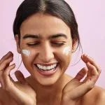 Studio shot of a beautiful young woman applying moisturizer to her face, Avene black friday 2023