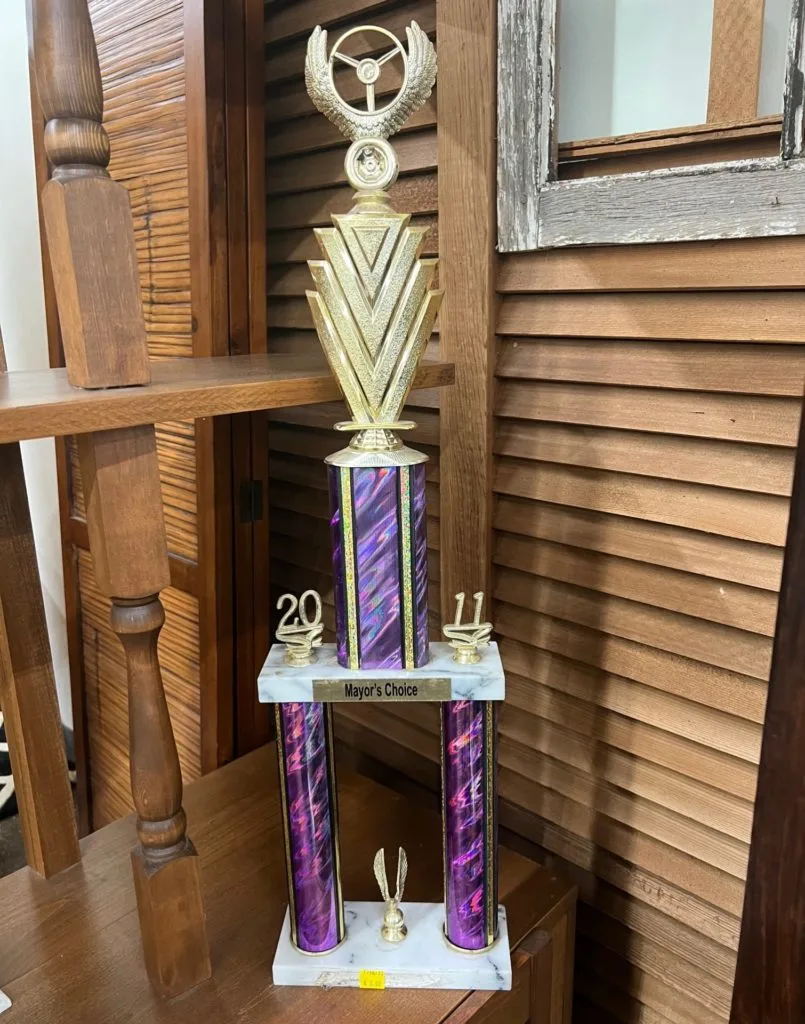A tall plastic trophy with white marble and purple embellishments. There is a gold label that says Mayor's Choice.