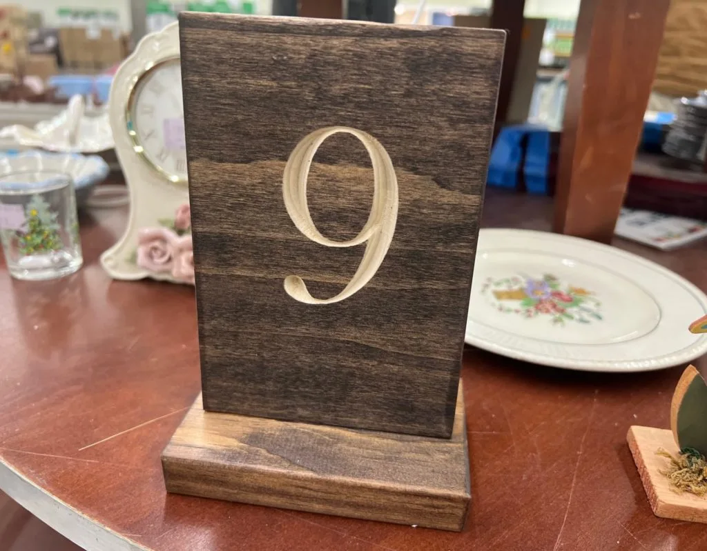 A wooden sign with the number 9 carved in it.