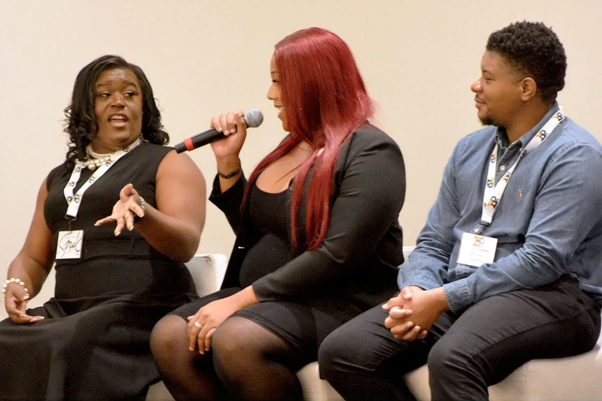 Naomi Green, actress Toni Bryce and Allyn Cropper are seated on a stage and talking with a mic