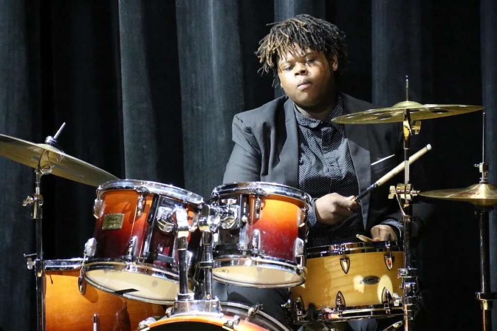 A student plays the drums