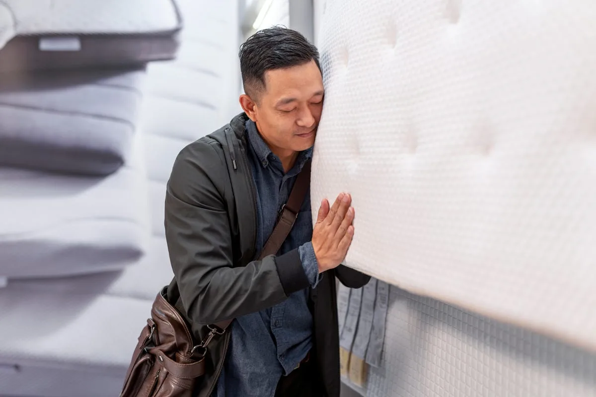 man hugging a mattress