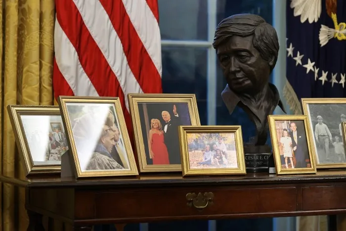 A black bust and framed photos on a desk