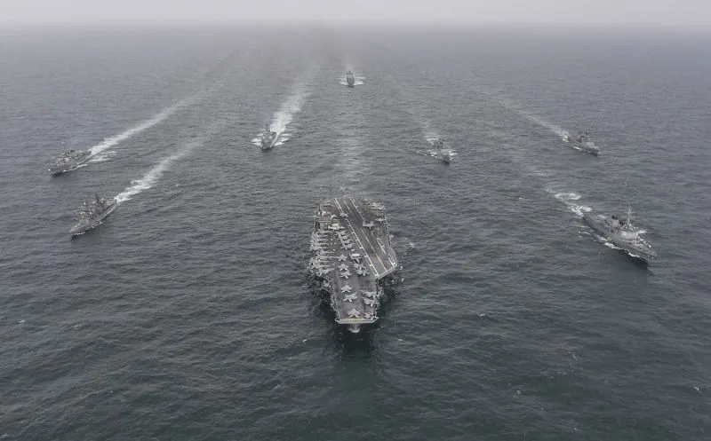 The USS Nimitz and Japan Maritime Self-Defense Force and South Korean Navy warships sail in formation during a joint naval exercise off the South Korean coast.