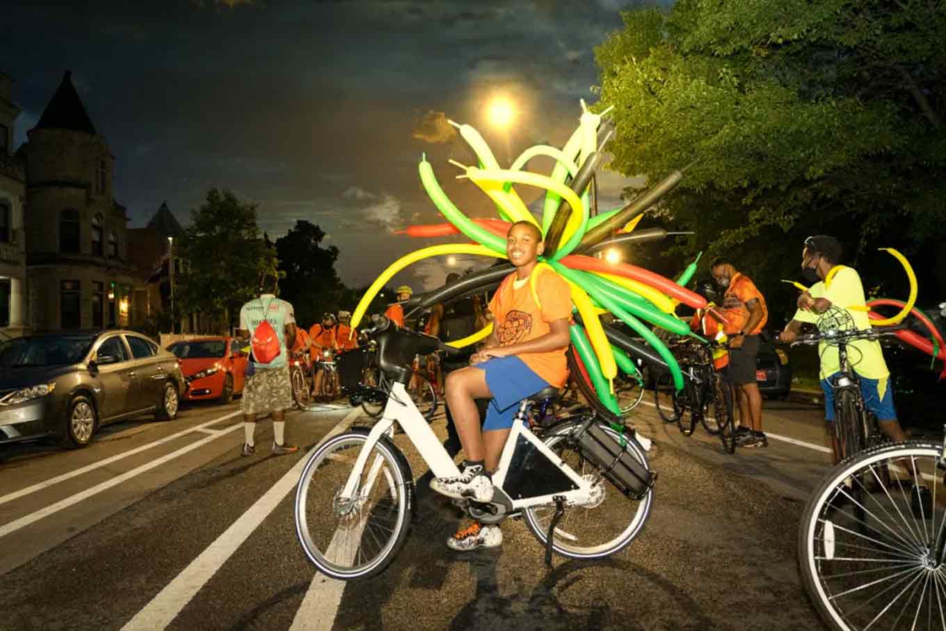 A Teen on a bike with balloons