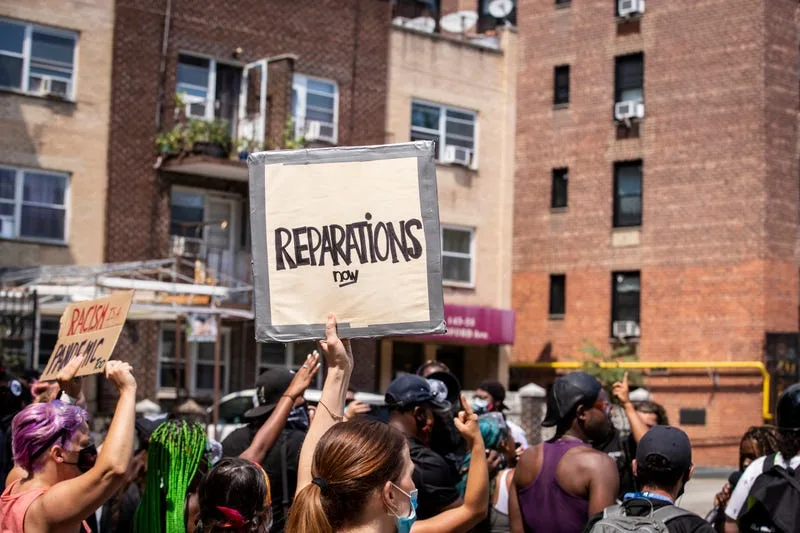 Protesters call for reparations as they walk through Bayside, Queens, on July 12, 2020